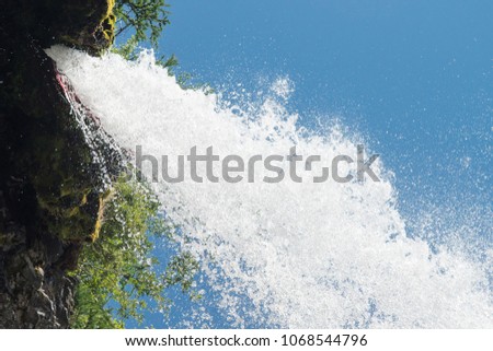 High waterfall flow on blue sky background