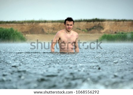 young man are in a river under the rain