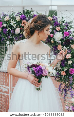 beautiful bride with a bouquet of flowers on a background of flowers