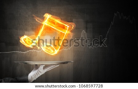 Cropped image of waitress's hand in white glove presenting flaming music symbol on metal tray with dark wall on background.