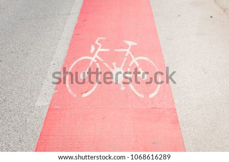 Bike lane painted in red as caution on the asphalt road with bicycle sign or symbol