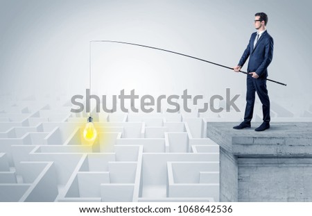 Young businessman fishing new idea concept on the top of a building from a maze