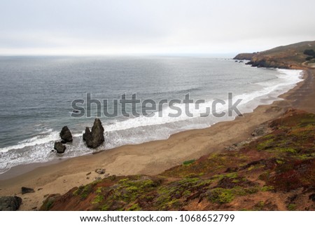 Rock formations sit on a long stretch of Rodeo Beach at Fort Cronkhite in Northern California Royalty-Free Stock Photo #1068652799
