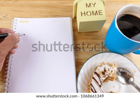 Business concept - Top view donut,notebook , pen, coffee cup, and phone on wood table.