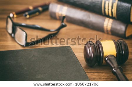 Court room. Law or auction gavel  and a hard cover book on a wooden office desk background. Closeup view, space for text