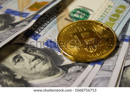 Cryptocurrency Bitcoin coin on background with american dollars.