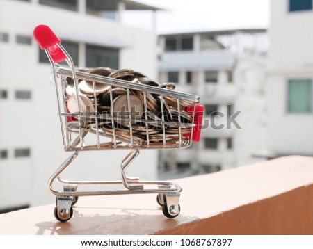shopping cart full of money with copy space and building or condo background - house loan concept