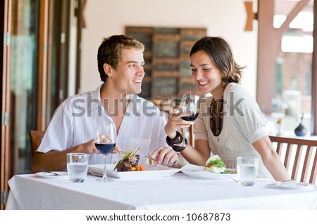 A young couple sitting at a table at an outdoor restaurant Royalty-Free Stock Photo #10687873