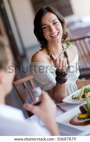 A young woman laughing whilst eating dinner at a restaurant Royalty-Free Stock Photo #10687879