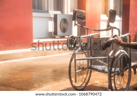 woman cleaning lower of old wheelchair by sponge,asian washing style