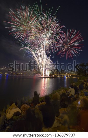 People Watching Fireworks Display Along the Banks of Willamette River in Portland Oregon Vertical