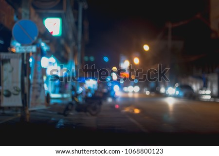 defocused night city life, cars, cyclist and street lamps