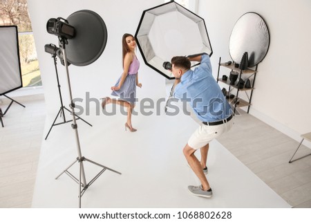 Beautiful young model posing for professional photographer in studio