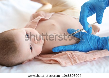 Doctor vaccinating baby in clinic Royalty-Free Stock Photo #1068805004