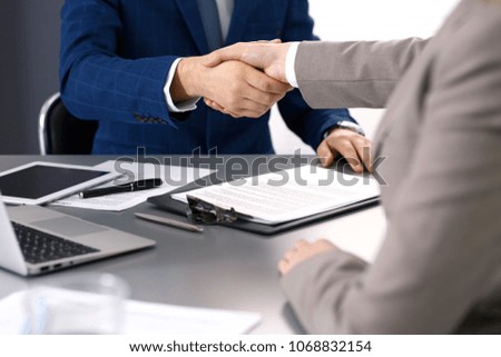 Business people shaking hands, finishing up a meeting. Papers signing, agreement and lawyer consulting concept