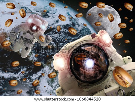 Astronauts in outer space with cheseburgers on the Earth and the Moon on the background. Elements of this image furnished by NASA