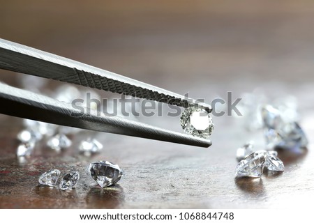 brilliant cut diamond held by tweezers Royalty-Free Stock Photo #1068844748