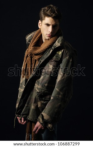 Portrait of young handsome man wearing coat and scarf.