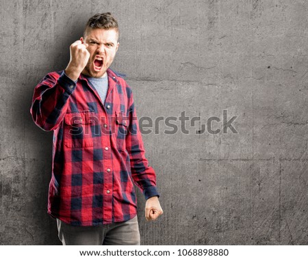 Young handsome man irritated and angry expressing negative emotion, annoyed with someone