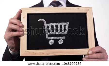 Shopping cart on blackboard in businessman hands, retail trade, consumer bundle, stock footage
