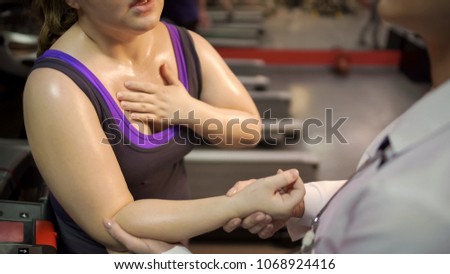 Woman breathing heavily, suffering tachycardia, doctor taking her pulse rate Royalty-Free Stock Photo #1068924416