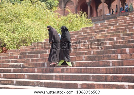 two Muslim women walking down stairs