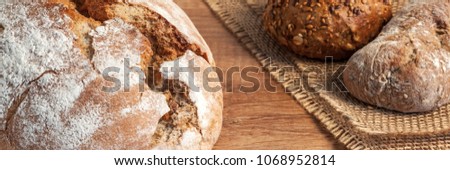 Panoramic view of a loaf of bread and rolls on a wooden table