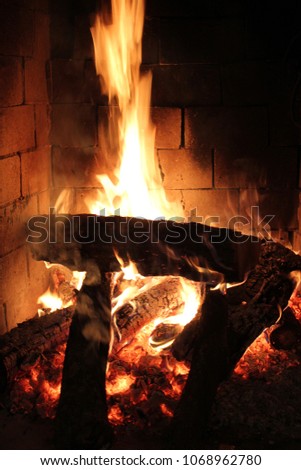 A brick fireplace with a fire.