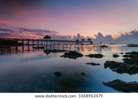 A Long exposure picture of golden sunrise with stone jetty