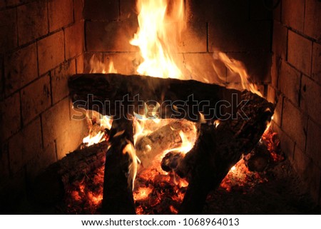 A brick fireplace with a fire.
