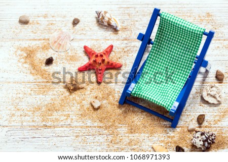 Beach Chair, Shells, Sand on white wooden board background card concept. Selective focus.