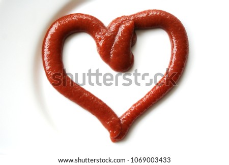 Ketchup in the form of a heart on dinner plate. Royalty-Free Stock Photo #1069003433