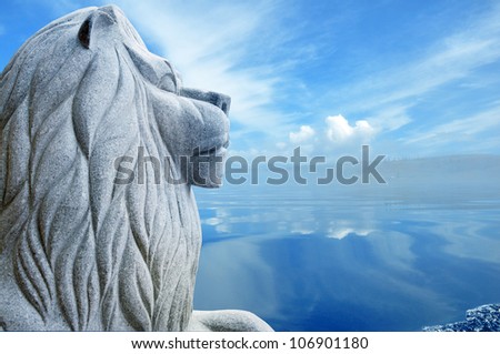 stone statue of a lion over blue lake