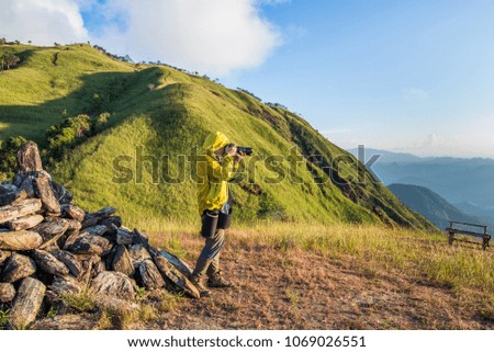 hiker man in yellow jacket standing on the mountain ridge take a photo the mountain range, beautiful nature in Doi Thule , Tak province , Thailand