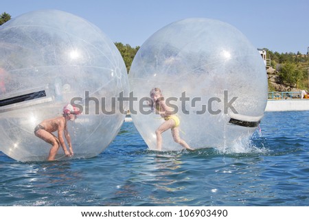 Joyful children in a balloon floating on water.