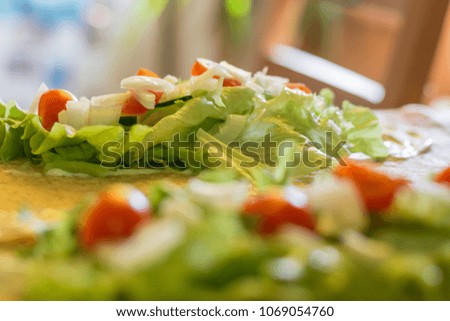 Making of meat, egg and cheese tortilla wrap. Fresh vegetables. 