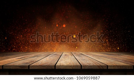 Old wood table with flame effect on dark background.  Royalty-Free Stock Photo #1069059887