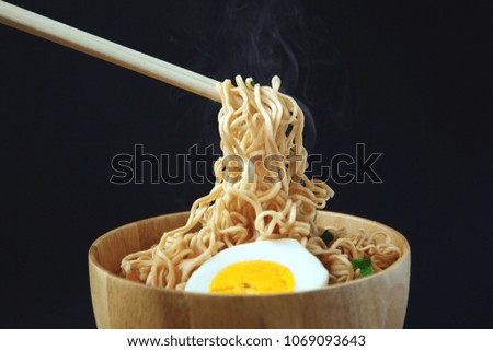 Noodles in bowl on wooden board.