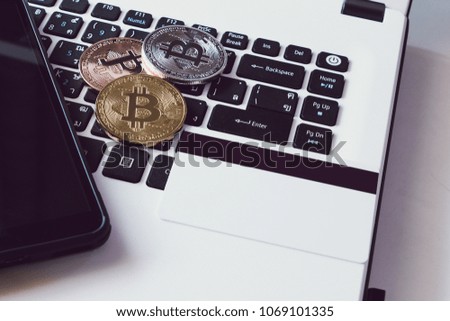 Bitcoin Cryptocurrency put on keyboard of notebook with credit card and smartphone.
