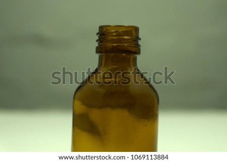 an old vintage pharmacy glass bottle on a vibrant pop pink background. Minimal color still life photography