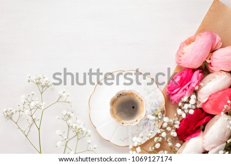 Top view to pink flowers and cup of coffee 
