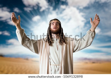 Jesus praying with his hands up against cloudy sky