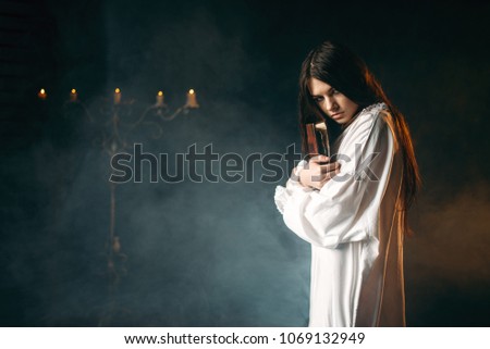 Woman holds spellbook in hands, witchcraft
