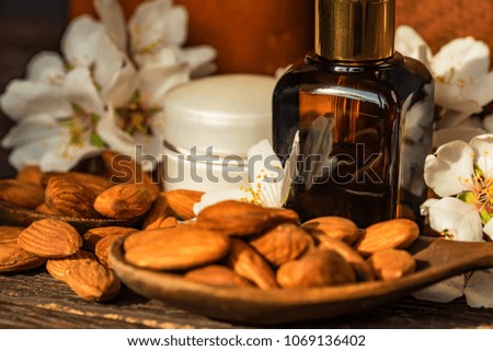 Almonds, oil, face cream and white flowers