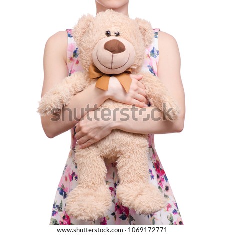 Woman in a dress floral print in the hands of a teddy bear on a white background isolation