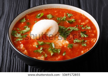 Fish soup with tomatoes, celery, onions, garlic and parsley close-up in a bowl on the table. horizontal
