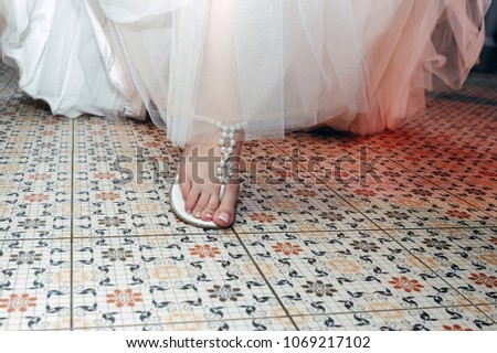 The bride in a luxurious wedding dress goes on a beautiful mosaic floor
