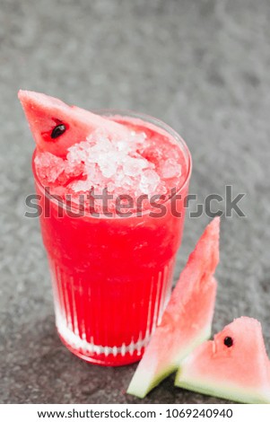 Cold watermelon smoothies with ice on the stone desk background
