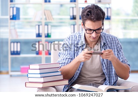 Student reading books and preparing for exams in library