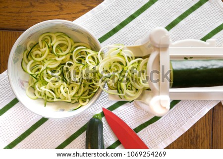 Spiral zucchini noodles called zoodles prepared in spiralizer kitchen gadget Royalty-Free Stock Photo #1069254269